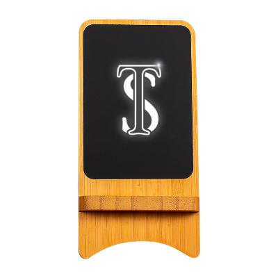 Maple bamboo wireless charger with an engraved logo.