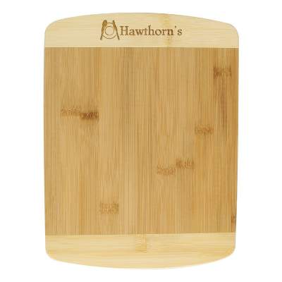 Two-tone bamboo cutting board with personalized laser engraved logo.